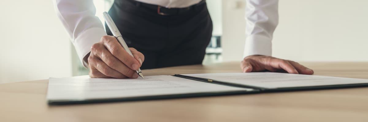 Homme qui signe un contrat de domiciliation